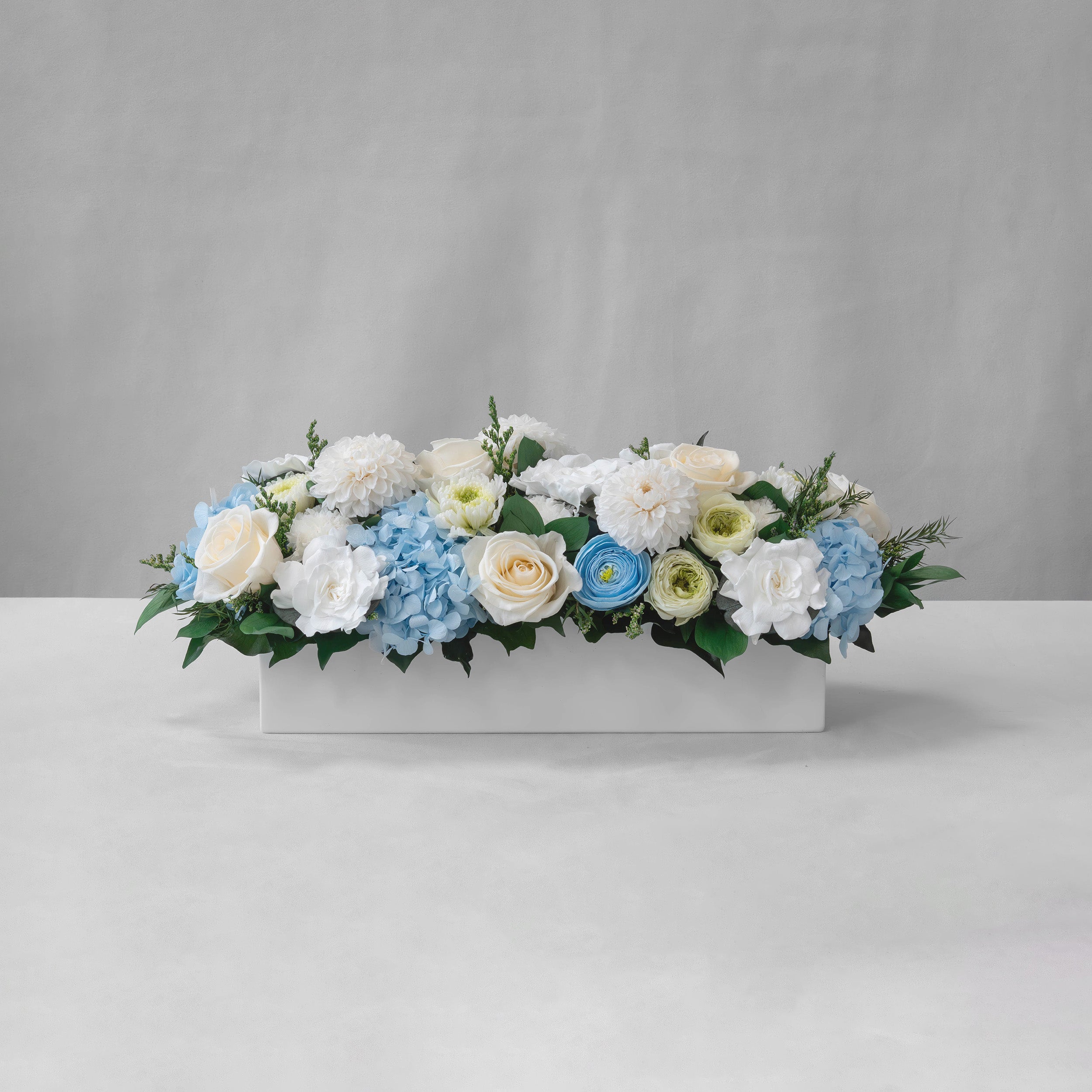Preserved blue, green and white tropical long low flower arrangement for yachts 