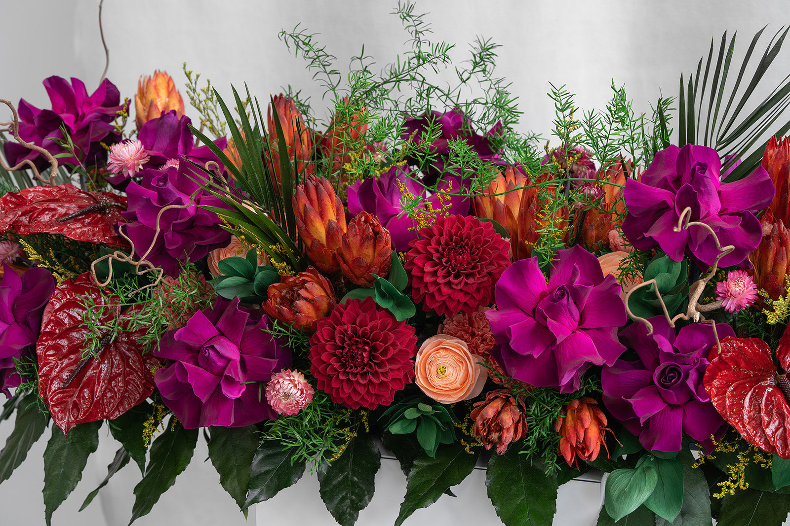 Preserved purple, peach and red mixed flower long low arrangement 