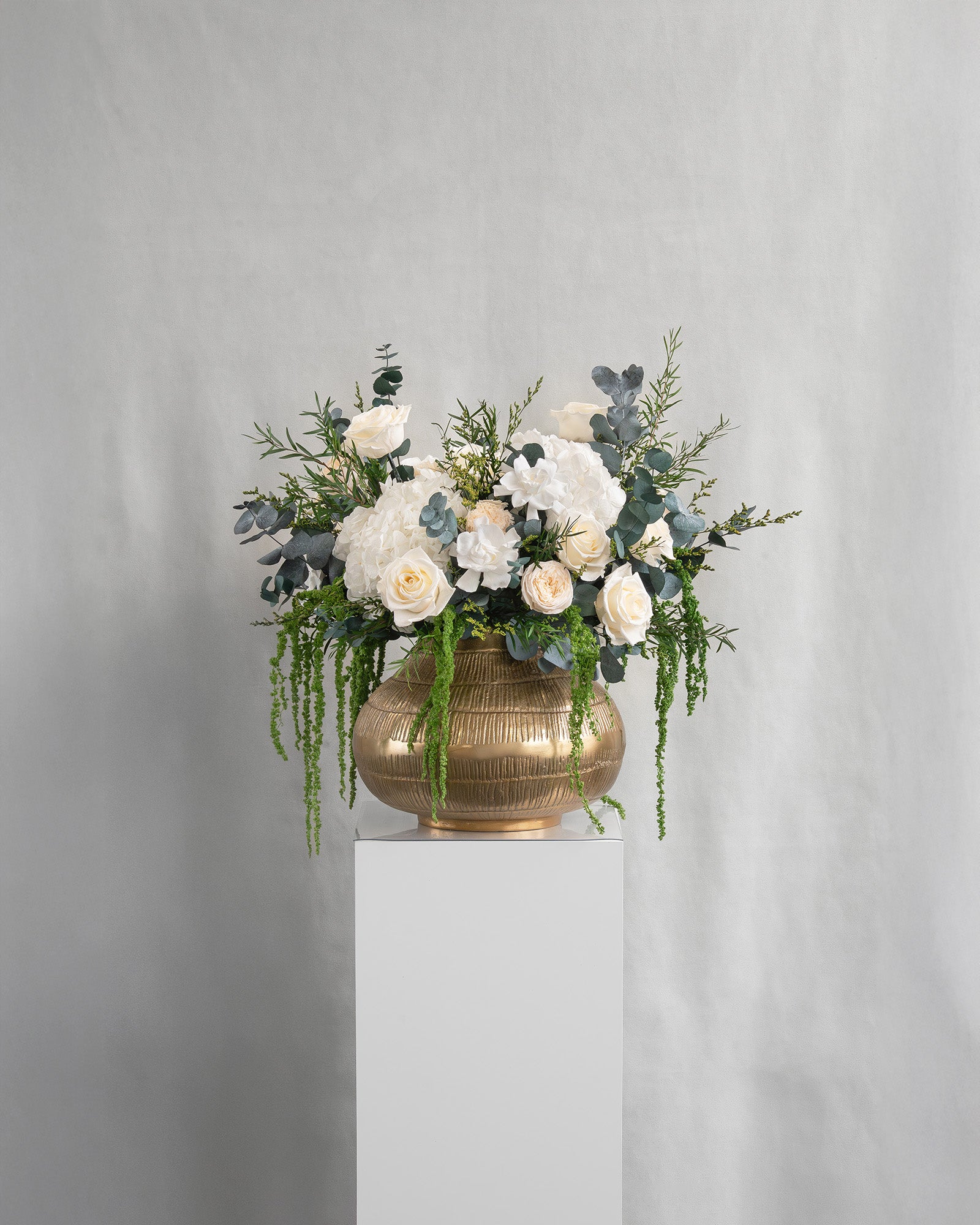 Preserved white mixed flower arrangement in gold vase