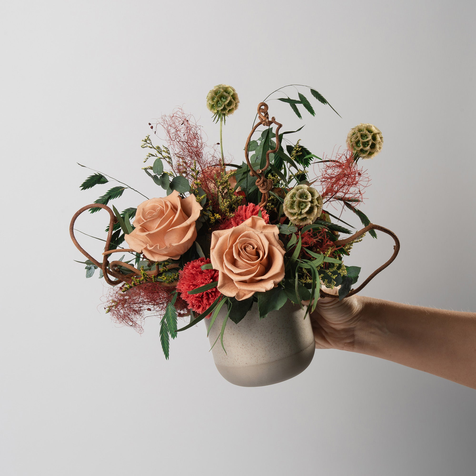 Preserved green and toffee floral arrangement in a ceramic vase for yachts interior. 