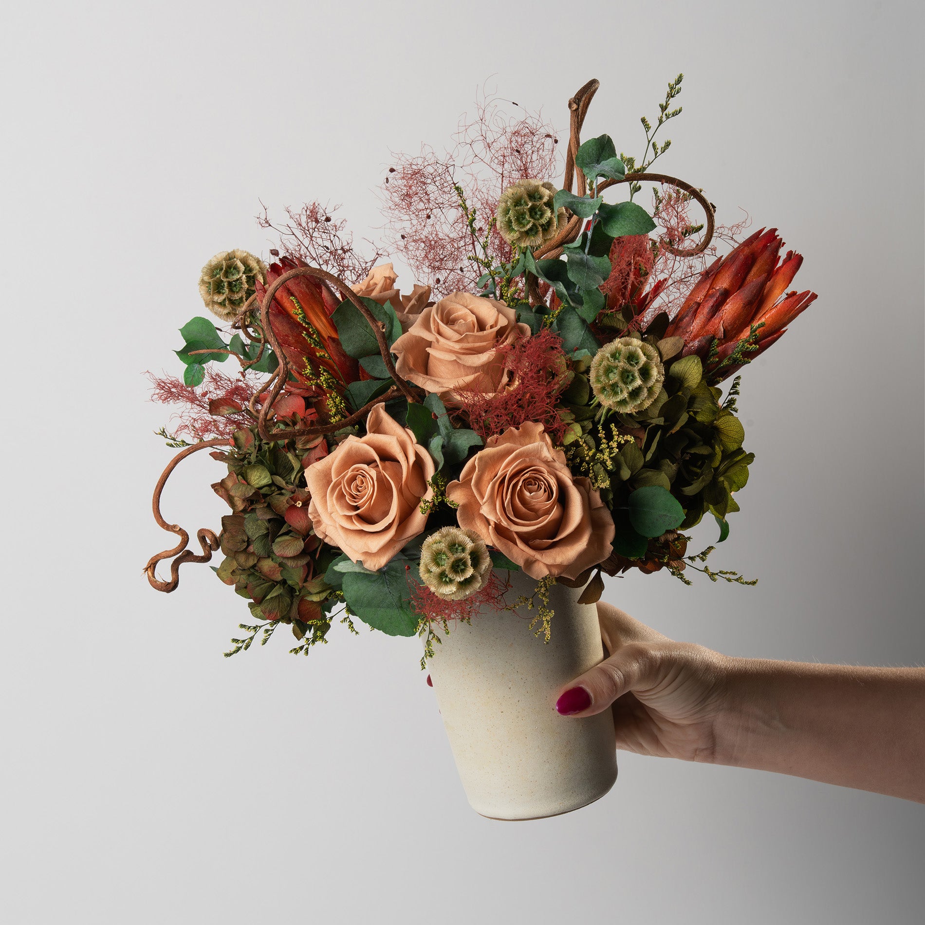 Bouquet of toffee and green mix preserved flowers in a ceramic vase for yachts