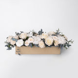 Preserved white and peach long low flower arrangement for yachts 